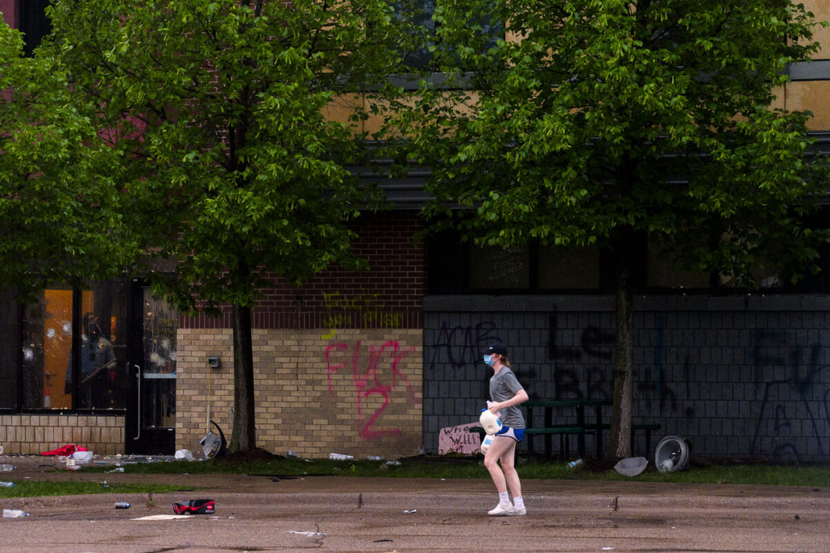 A woman holding jugs of milk outside the Minneapolis Police 3rd Precinct during protests the day after George Floyd was killed.