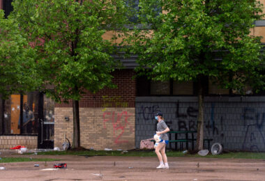 A woman holding jugs of milk outside the Minneapolis Police 3rd Precinct during protests the day after George Floyd was killed.