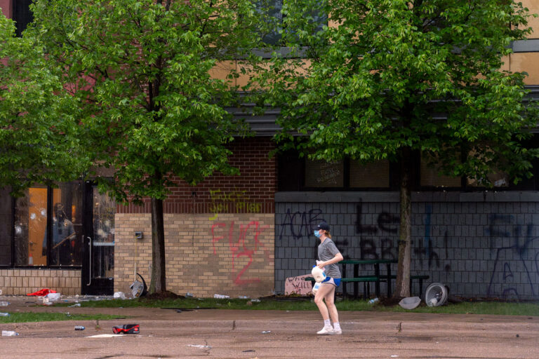 Protester with milk at the Minneapolis Police 3rd Precinct 1 A woman holding jugs of milk outside the Minneapolis Police 3rd Precinct during protests the day after George Floyd was killed.