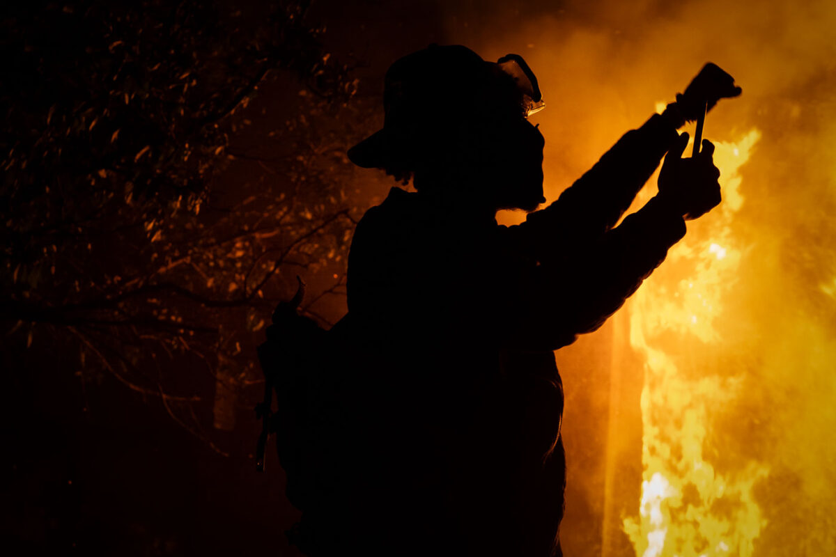 A protester holds up his first as the Minneapolis Police 3rd Precinct burns in the background. This was on the 3rd day of protests in Minneapolis following the death of George Floyd.