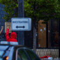 Protesters hold their fists up outside the Minneapolis Police 3rd Precinct police station. Police officers behind broken glass on day 1 of protests after the death of George Floyd the night before.