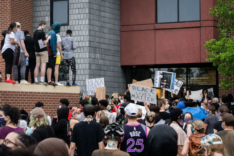 Minneapolis Police Third Precinct 3 Protesters with signs outside the back door of the Minneapolis police third precinct.