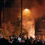 The Minneapolis Police 3rd Precinct on fire as protesters surround it after days of protest. The precinct was Derek Chauvin’s home precinct and was set ablaze after the police abandoned the precinct following days of protests over the death of George Floyd.