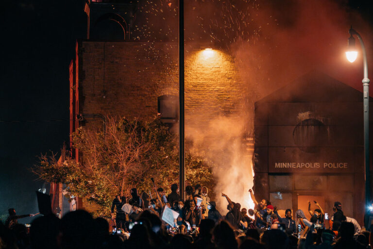 Protesters outside the burning 3rd precinct 2 The Minneapolis Police 3rd Precinct on fire as protesters surround it after days of protest. The precinct was Derek Chauvin’s home precinct and was set ablaze after the police abandoned the precinct following days of protests over the death of George Floyd.