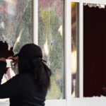 Someone takes a photo through the broken windows of the Target Store on East Lake Street.