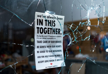 Broken storefront window during the riots on the 2nd day of protests in Minneapolis following the death of George Floyd. 

Sign hanging in the window reading "We've always been in this together. During the covid 19 pandemic & ALWAYS, it is our shared responsibility to- Take care of our bodies. Be gentle with our hearts. Be good to our neighbors. Ask for help when we need it. Accept love when it arrives. Our impact matters.