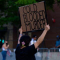 A protester holds up a sign reading "Cold Blooded Murder" outside the Minneapolis police third precinct.