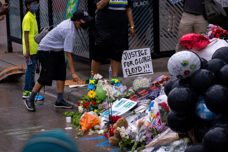 38th St. and Chicago Ave. 2 A woman leaves flowers outside of Cup Foods the day after George Floyd was killed.