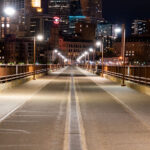 Woman looks over the railing on the Stone Arch Bridge in downtown Minneapolis.