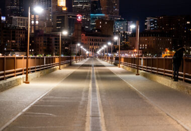 Woman looks over the railing on the Stone Arch Bridge in downtown Minneapolis.