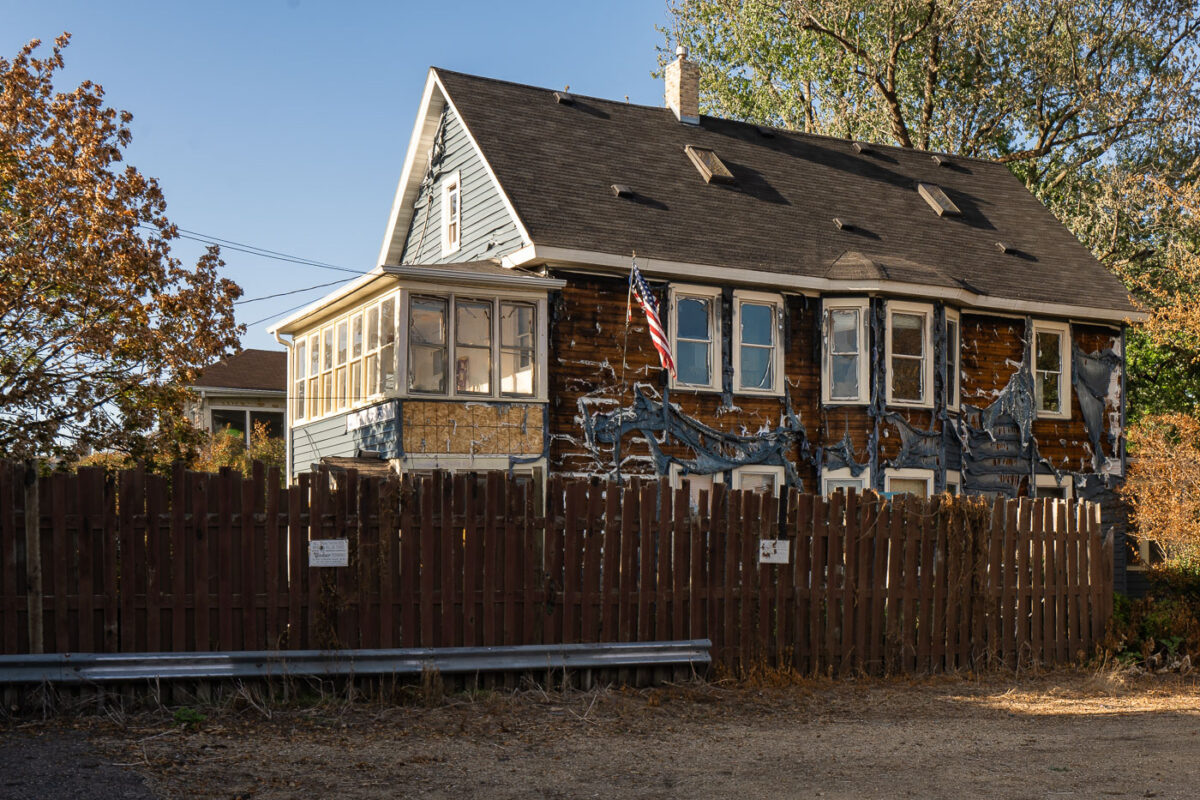 Siding burned off a building in South Minneapolis with an American Flag hanging from it. The heat from nearby fires burned the siding off.