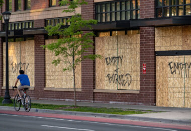 A cyclist bikes down Hennepin Avenue in Uptown Minneapolis past a boarded up Walgreens Pharmacy. 

Boards were placed after unrest in Minneapolis over the killing of George Floyd on May 25th, 2020.