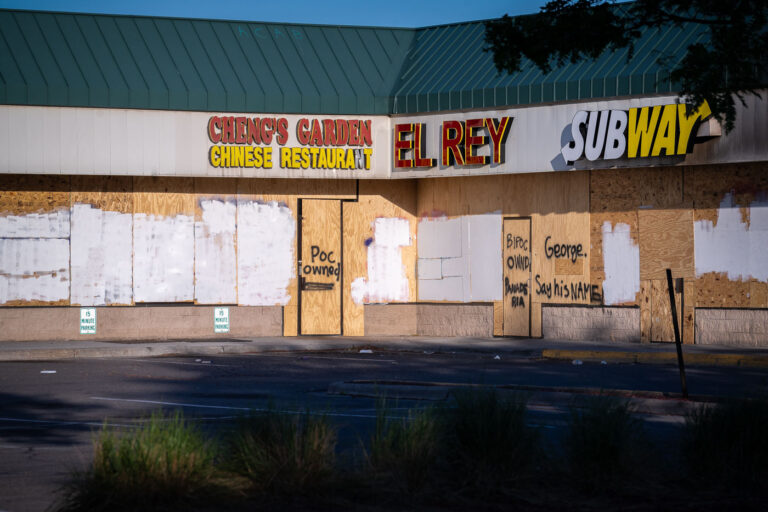 Strip mall with George Floyd boards 1 Boards on a strip mall in South Minneapolis during unrest in Minneapolis following the May 25th, 2020 death of George Floyd.Boards reading “Say His Name” “POC Owned” “BIPOC Owned”