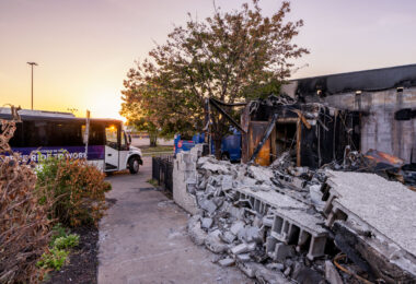 A bus stops outside the former Atlus Staffing building on East Lake Street. The building was burned following the death of George Floyd.