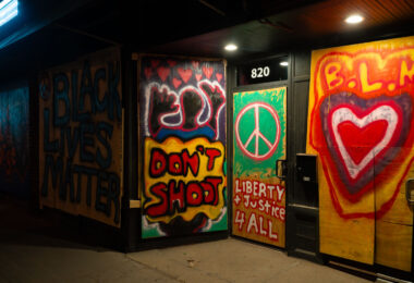 Boards over businesses on Lake Street in Uptown Minneapolis. Reading "Black Lives Matter" "Liberty & Justice.4 All".