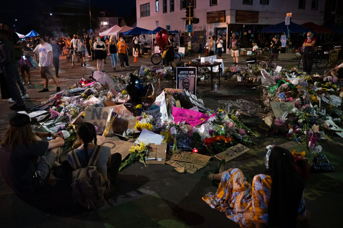 Flowers and signs left behind at a memorial in middle of 38th St and Chicago Ave on 06/04/20.