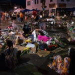 Flowers and signs left behind at a memorial in middle of 38th St and Chicago Ave on 06/04/20.