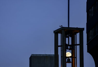 A full moon rising behind church bells in Downtown Minneapolis.
