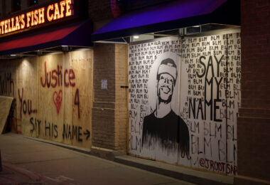 Boards reading "Say His Name" "Justice" and a drawing of George Floyd on Stella's Fish Cafe windows on Lake Street in Uptown Minneapolis. June 2020