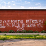 Graffiti reading “We love our postal patrons! We will be back to serve you”. The post office was destroyed in the days following George Floyd May 2020 murder.
