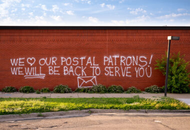 Graffiti reading “We love our postal patrons! We will be back to serve you”. The post office was destroyed in the days following George Floyd May 2020 murder.