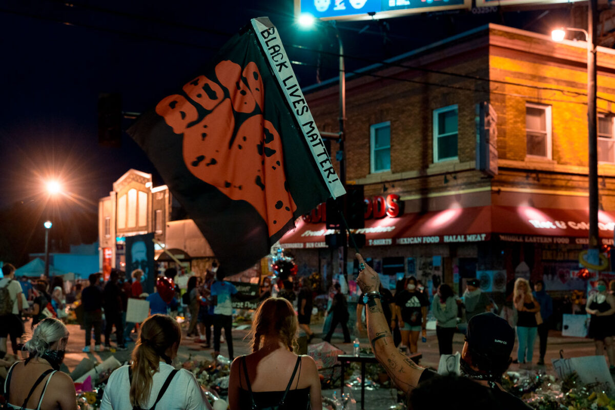 Protester holds up a “Black Lives Matter” flag at 38th St and Chicago Ave where George Floyd died on May 28th, 2020.