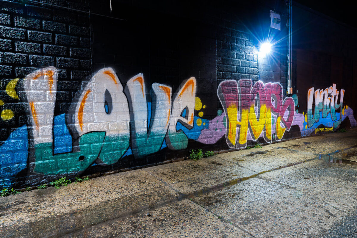 Graffiti that reads "Love Hope Unity" on the side of a building in uptown.