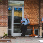 Minneapolis Police stand outside an entrance to the Sheraton Hotel in Midtown Minneapolis while clearing and boarding it.