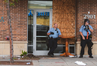 Minneapolis Police stand outside an entrance to the Sheraton Hotel in Midtown Minneapolis while clearing and boarding it.
