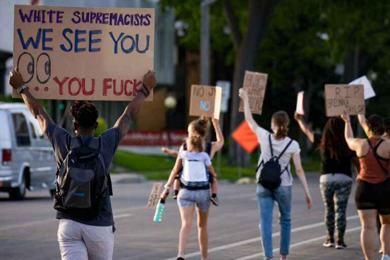 White Supremacists We See you 1 Protester holds up a sign reading “White supremacists We See You… you fucks” as they march down Park Avenue into downtown Minneapolis.
