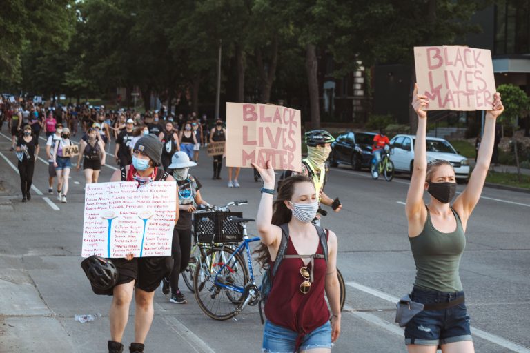 Protesters hold signs marching down Park Ave, Minneapolis 2 Protesters hold signs up marching down Park Avenue