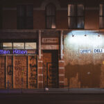 Boards over Caffrey's Deli and Smitten Kitten on Lyndale Avenue during protests following the murder of George Floyd. Boards reading "Don't burn we live here" "We want cops in Cuffs" "People live here, kids live here".