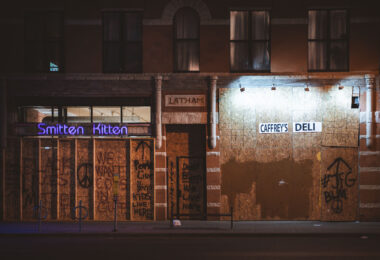 Boards over Caffrey's Deli and Smitten Kitten on Lyndale Avenue during protests following the murder of George Floyd. Boards reading "Don't burn we live here" "We want cops in Cuffs" "People live here, kids live here".
