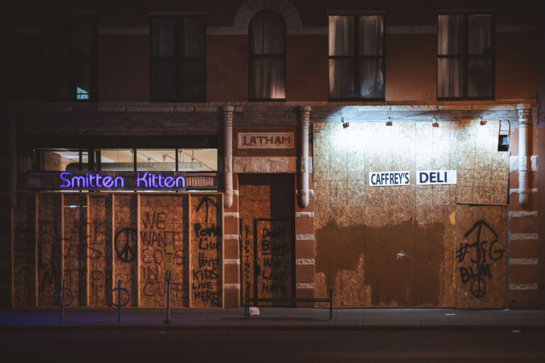 Caffrey's Deli and Smitten Kitten boarded up 2 Boards over Caffrey's Deli and Smitten Kitten on Lyndale Avenue during protests following the murder of George Floyd. Boards reading "Don't burn we live here" "We want cops in Cuffs" "People live here, kids live here".