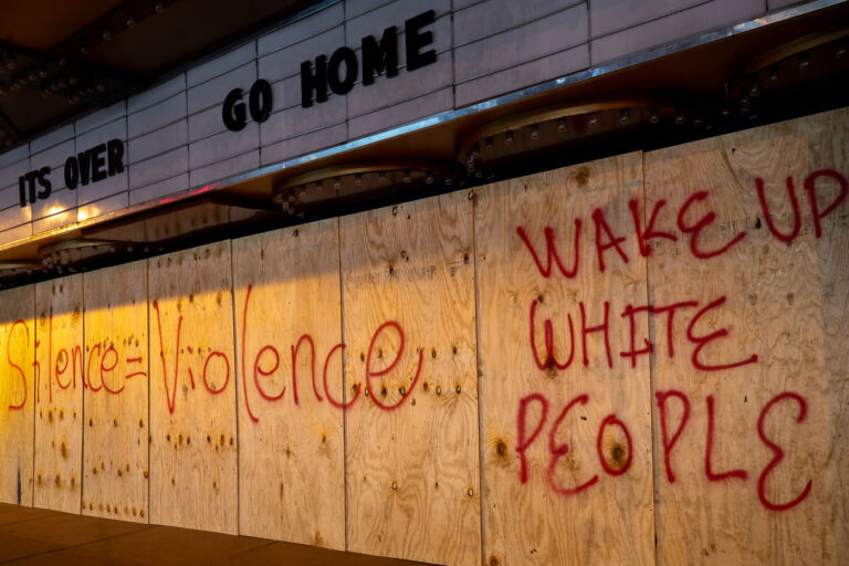 Silence equals violence 2 Boarded up Uptown Theater in Uptown Minneapolis with boards reading “Silence = Violence” and “Wake Up White People”.