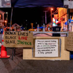 A welcome table at the George Floyd memorial on 38th Street. George Floyd was killed around the corner the previous month.A sign reads: “This is a sacred healing space for the black and African American community it is bein served by their aliy communities and is a holy ground”.