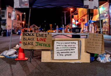 A welcome table at the George Floyd memorial on 38th Street. George Floyd was killed around the corner the previous month.

A sign reads: “This is a sacred healing space for the black and African American community it is bein served by their aliy communities and is a holy ground”.