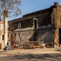 Woman walking in front of the remains of Chicago Furniture. The store was burned during unrest in Minneapolis following the May 25th, 2020 death of George Floyd.