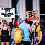 Protesters hold up signs outside the Federal Courthouse in downtown Minneapolis. “All My Homes Hate Fascism”. The protest and rally was regarding Federal officers being deployed to other cities during protests.
