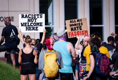 Protesters hold up signs outside the Federal Courthouse in downtown Minneapolis. “All My Homes Hate Fascism”. The protest and rally was regarding Federal officers being deployed to other cities during protests.