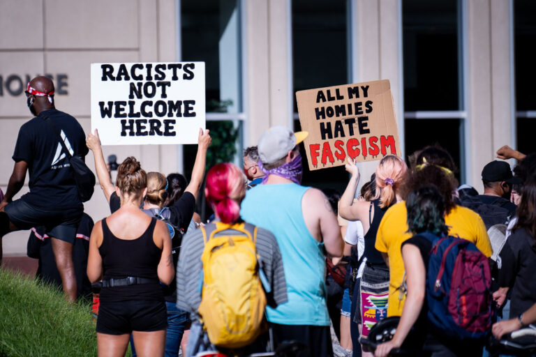 Racists Not Welcome Here 1 Protesters hold up signs outside the Federal Courthouse in downtown Minneapolis. “All My Homes Hate Fascism”. The protest and rally was regarding Federal officers being deployed to other cities during protests.