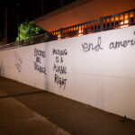 Stolen Land, Housing is a human right, end America written on the side of the Hennepin County Medical Center.