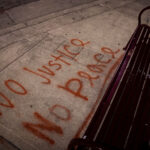 No Justice, No Peace written on the sidewalk in front of a bench in South Minneapolis.