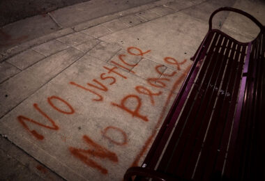 No Justice, No Peace written on the sidewalk in front of a bench in South Minneapolis.