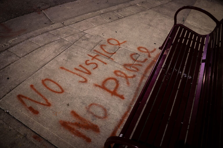 No Justice No Peace in front of bench 2 No Justice, No Peace written on the sidewalk in front of a bench in South Minneapolis.