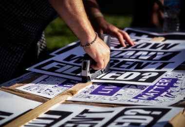 Protest signs being stapled together prior to the “How many weren’t filmed?” March through Uptown Minneapolis.