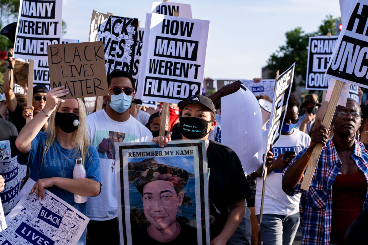 Protesters holding up signs reading “How many weren’t filmed?” during a July 24, 2020 march through Uptown Minneapolis.