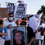 Protesters holding up signs reading “How many weren’t filmed?” during a July 24, 2020 march through Uptown Minneapolis.