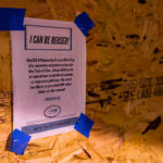 ReUSE Minnesota flyer on storefront board. The organization is coordinating the recovery of plywood across the twin cities after it was used to cover doors and windows.