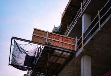Construction site in downtown Minneapolis with wood that reads “Stay happy stay safe”.